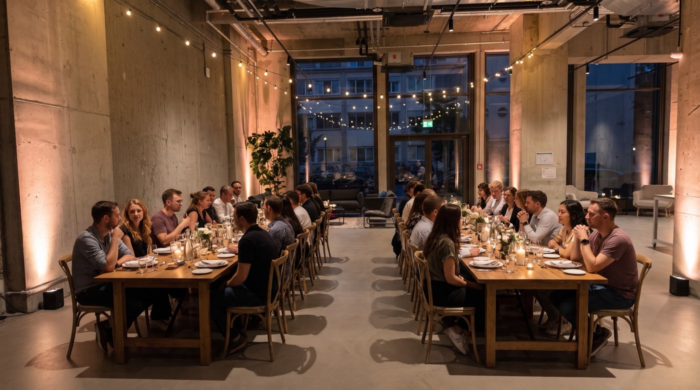 Long banquet tables set for a team dinner by candlelight at The Delta Berlin