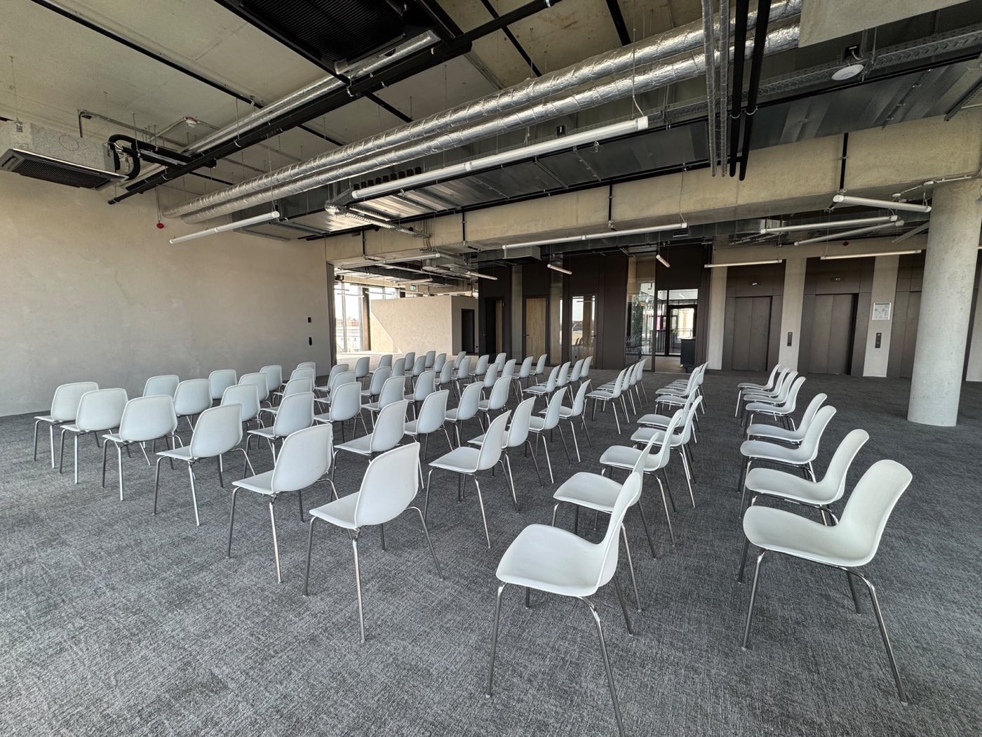 Rows of seating on The Observatory main floor, the breakout rooms behind